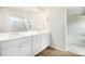 Elegant bathroom featuring double sinks, wood-look flooring, and a glimpse into the bedroom at 25 Running Terrace Way, Cartersville, GA 30121