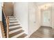 Hallway view featuring hardwood floors, a front door, and a staircase with iron spindles at 25 Running Terrace Way, Cartersville, GA 30121