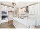 A modern white kitchen featuring stainless steel appliances, quartz countertops and a center island sink at 25 Running Terrace Way, Cartersville, GA 30121