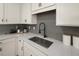 Close-up of a modern kitchen sink with gray backsplash, white cabinets, and quartz countertops at 208 Bastian Dr # 108, Villa Rica, GA 30180