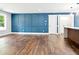 Living room featuring a striking blue accent wall and sleek, dark wood floors at 38 Creek Se Dr, Cartersville, GA 30121