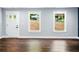 A bright and airy room with wood floors and natural light streaming in from windows on either side of a white door at 38 Creek Se Dr, Cartersville, GA 30121