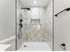 A detailed shot of a shower adorned with marble tile and complemented by sleek, matte black fixtures at 38 Creek Se Dr, Cartersville, GA 30121