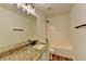Well-lit bathroom boasts granite counters, modern vanity, shower, and tub combination at 7196 Toccoa Circle, Union City, GA 30291