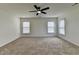 Spacious bedroom featuring neutral carpeting, a ceiling fan, and natural light from the large window at 7196 Toccoa Circle, Union City, GA 30291