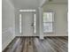 Bright foyer with white door, side lights, transom window, column and wood grain floors at 7196 Toccoa Circle, Union City, GA 30291