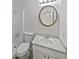 Cozy bathroom features tile flooring, a round mirror, and a shower with glass doors at 978 Monopoly Dr, Lawrenceville, GA 30046