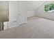 Light-filled bedroom featuring neutral carpeting and access to the stairs at 978 Monopoly Dr, Lawrenceville, GA 30046