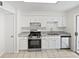 Modern kitchen with white cabinets, granite countertops, stainless steel appliances, and tile flooring, perfect for cooking at 978 Monopoly Dr, Lawrenceville, GA 30046