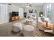 Staged living room featuring a comfortable sofa, stylish chairs, a modern rug, and ample natural light from large windows at 978 Monopoly Dr, Lawrenceville, GA 30046