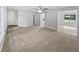 Large living room with neutral carpet, multiple entryways, and a glimpse of the dining area, offering versatility at 978 Monopoly Dr, Lawrenceville, GA 30046