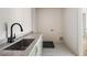 Well-lit laundry room with stainless steel sink, stone countertop, and patterned tile flooring at 2609 Dogwood Terrace Ne, Atlanta, GA 30319