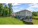 Spacious backyard with lush green grass, play set, trampoline and covered patio area at 3420 Pleasant Springs Dr, Cumming, GA 30028
