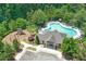 Aerial view of the community pool, clubhouse, and playground with mature trees at 3420 Pleasant Springs Dr, Cumming, GA 30028