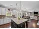 Well-lit kitchen with white cabinets, granite counters, an island, and views into the living space at 3420 Pleasant Springs Dr, Cumming, GA 30028