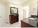 Bathroom showcasing a vanity with dark wood cabinets and black countertop, tile floor and white doors at 3541 Roswell Ne Rd # 20, Atlanta, GA 30305