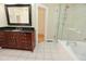Bathroom features tile floor, glass shower, soaking tub and vanity with dark wood cabinets and black countertop at 3541 Roswell Ne Rd # 20, Atlanta, GA 30305