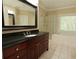 Bathroom vanity with dark wood cabinets, black countertop, glass shower and soaking tub near a bright window at 3541 Roswell Ne Rd # 20, Atlanta, GA 30305