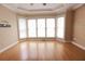 Bedroom with wood floor, tray ceiling, wallpapered accent wall, and a bank of windows with blinds at 3541 Roswell Ne Rd # 20, Atlanta, GA 30305