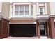 Charming townhome featuring a two-car garage, brick accents, and multiple windows at 3541 Roswell Ne Rd # 20, Atlanta, GA 30305