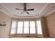 Bright room featuring a ceiling fan, tray ceiling, and large windows with blinds at 3541 Roswell Ne Rd # 20, Atlanta, GA 30305