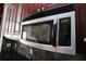 Close up of stainless steel microwave above dark wood cabinetry and stone backsplash at 3541 Roswell Ne Rd # 20, Atlanta, GA 30305