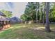 Backyard with a grass lawn, mature trees, and a privacy fence at 1464 Claredon Dr, Lawrenceville, GA 30043