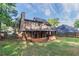 View of the house from the backyard with the covered porch, and trees around the perimeter at 1464 Claredon Dr, Lawrenceville, GA 30043
