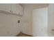 Small laundry room with upper cabinets, connections for the appliances, and tile floor at 1464 Claredon Dr, Lawrenceville, GA 30043