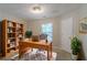 Office with a wooden desk, large bookcase, and natural light at 1464 Claredon Dr, Lawrenceville, GA 30043