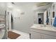 Bathroom featuring a single sink vanity, a mirror, and a white tiled floor at 5204 Tealing Ne Dr, Roswell, GA 30075