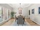 Bright dining room with tray ceiling, large windows, modern light fixture, and hardwood flooring at 5204 Tealing Ne Dr, Roswell, GA 30075