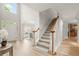 Open foyer featuring hardwood floors, staircase with wooden handrail, and abundant natural light at 5204 Tealing Ne Dr, Roswell, GA 30075