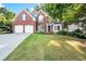 Traditional brick home with a well-manicured lawn, two-car garage, and inviting entrance at 5204 Tealing Ne Dr, Roswell, GA 30075