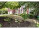 The front of this home is beautifully landscaped with shrubbery and decorative stone at 5204 Tealing Ne Dr, Roswell, GA 30075