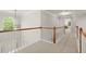 Hallway with carpet, a wooden railing, and natural light from an arched window at 5204 Tealing Ne Dr, Roswell, GA 30075