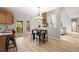 Open-concept kitchen and dining area with light-colored cabinetry, stainless appliances, and access to outdoor deck at 5204 Tealing Ne Dr, Roswell, GA 30075