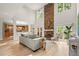 Bright living room features a stone fireplace, soaring ceilings, large windows, and an open floor plan with access to the kitchen at 5204 Tealing Ne Dr, Roswell, GA 30075