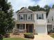 Charming two-story home featuring a cozy front porch, attached garage, and well-maintained landscaping at 5345 Mountain Top Pl, Cumming, GA 30041