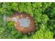 Aerial view of a home with a gray roof surrounded by lush green trees and a pathway leading to the property at 1687 Harmony Rd, Temple, GA 30179