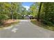 View of new construction home featuring a long driveway surrounded by mature hardwood trees at 1687 Harmony Rd, Temple, GA 30179