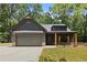 Charming home with neutral siding, a two-car garage, and inviting front porch with rustic columns at 1687 Harmony Rd, Temple, GA 30179