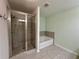Updated bathroom with a glass-enclosed shower and separate soaking tub at 5535 Bright Cross Way, Suwanee, GA 30024