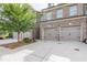 Brick townhome showcasing a two-car garage and concrete driveway at 5535 Bright Cross Way, Suwanee, GA 30024