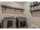 Laundry room with front load washer and dryer and storage shelf at 5535 Bright Cross Way, Suwanee, GA 30024