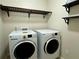 Functional laundry area features front loading washer/dryer set and storage shelves at 5535 Bright Cross Way, Suwanee, GA 30024