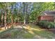 A large backyard features mature trees and lush landscaping at 8900 River Trace Dr, Johns Creek, GA 30097