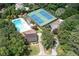 Aerial view of a community pool and tennis courts surrounded by lush trees and landscaping at 1096 Polo Club Nw Dr, Marietta, GA 30064