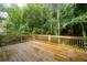 Wood deck with railings overlooking the lush, green backyard and trees at 1096 Polo Club Nw Dr, Marietta, GA 30064