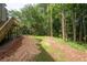 Home's backyard featuring a slope to the grass and treeline at 1096 Polo Club Nw Dr, Marietta, GA 30064